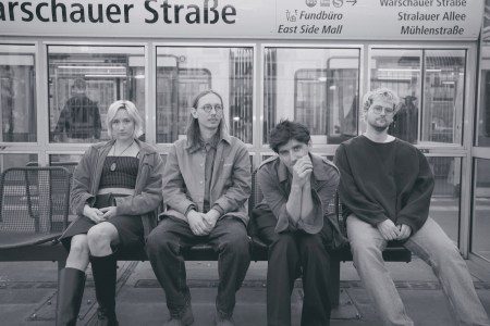 La band Dusk Saffron è seduta su una panchina. La foto è in bianco e nero